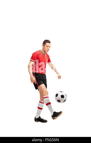 Full length portrait of a young male football player juggling a ball isolated on white background Stock Photo