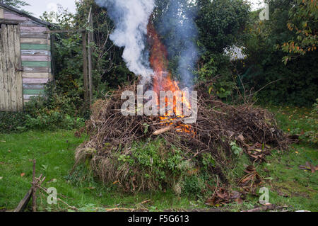 An autumn bonfire burns the woody garden waste from a clear up Stock Photo