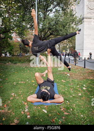 Two athletic fit men do acro yoga exercises in Washington Square Park in New York City Stock Photo