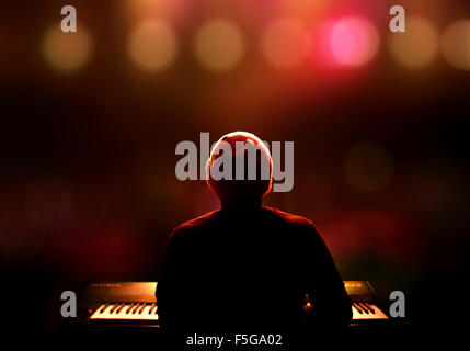 Pianist playing the synthesizer live on stage. Seen from behind with extreme shallow DOF Stock Photo