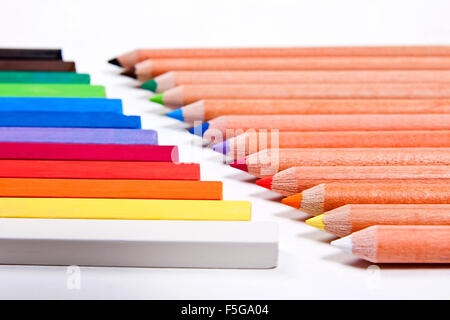 View of different color pencils and chalk pastels isolated on the white background. Drawing supplies: assorted color pencils and Stock Photo