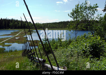 Hand made fence in old stile with only wood as used parts and with a lake in the background, photo from North of Sweden. Stock Photo