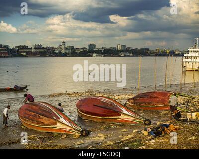 Nov. 4, 2015 - Dala, Yangon Division, Myanmar - Small wooden ferries are repaired on the banks of the Yangon River in Dala. Dala is located on the southern bank of Yangon River across from downtown Yangon, Myanmar. Many Burmese live in Dala and surrounding communities and go across the river into central Yangon for work. Before World War 2, the Irrawaddy Flotilla Company had its main shipyards in Dala. That tradition lives on in the small repair businesses the work on the hundreds of small wooden boats that serve as commuter ferries for the people of Yangon. The boats are pulled up onto the ri Stock Photo