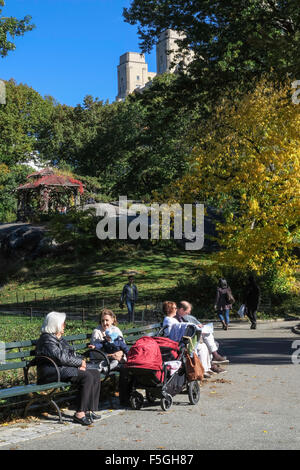 Park Visitors on Benches Near Wooden Gazebo in Central Park, NYC, USA Stock Photo