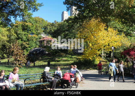 Park Visitors on Benches Near Wooden Gazebo in Central Park, NYC, USA Stock Photo