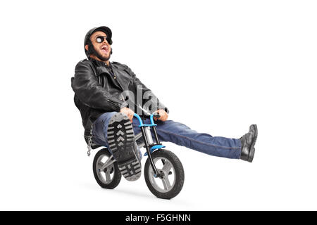 Carefree young biker in black leather jacket riding a small bicycle isolated on white background Stock Photo