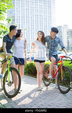 Happy young adults riding bicycles Stock Photo