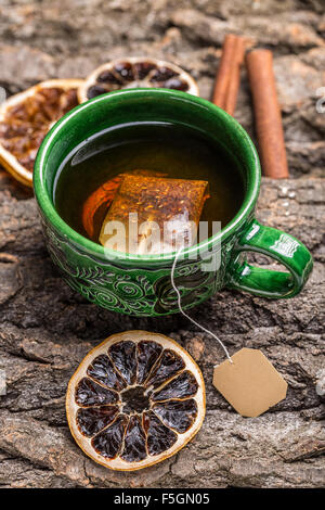 Cup of tea with tea bag on bark wooden background Stock Photo