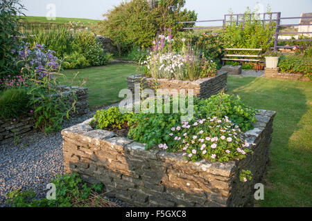 Raised flower beds with stone borders, Ireland Stock Photo