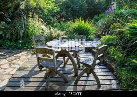 Wooden patio table and chairs in large country garden Stock Photo