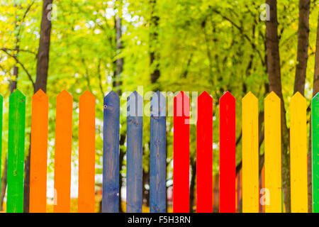 Multi colored rainbow wooden fence in autumn, garden background, soft focus, shallow depth of field Stock Photo