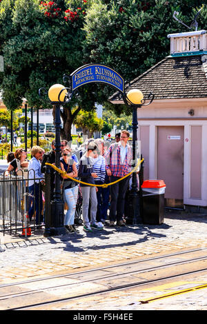 Line of people waiting to hop onto the famous Cable car at the end of the Powell & Hyde line in San Francisco CA Stock Photo