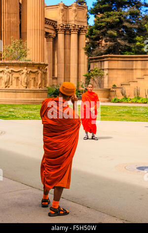 Buddist monks takes tourist photos with a digital camera at the Palace of Fine Arts in the Marina District of San Francisco CA Stock Photo