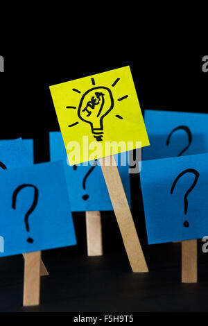 conceptual image of a good idea standing out using sticky notes with hand drawn questions marks and a light bulb Stock Photo