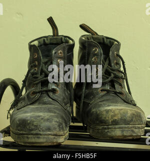 old soldier's boots worn with scratches and untied shoelaces Stock Photo