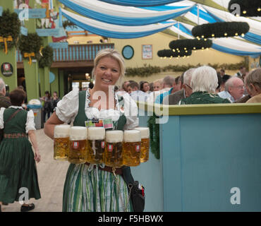 Waitress carrying masses of beer at Oktoberfest in Munich, Germany Stock Photo