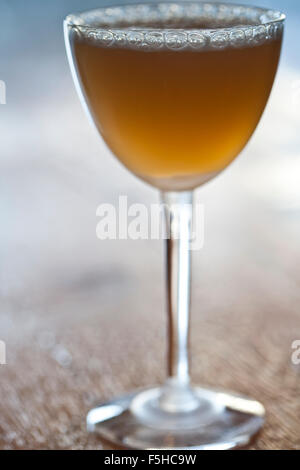 tight vertical shot of an amber colored cocktail in stemmed glass, Stock Photo