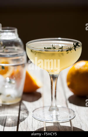 lemon cocktail in stemmed glass with lemon and cocktail shaker Stock Photo