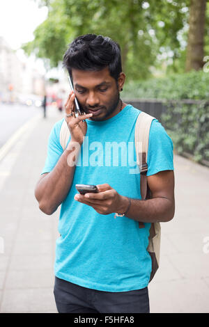 young man  with two phones making a call Stock Photo