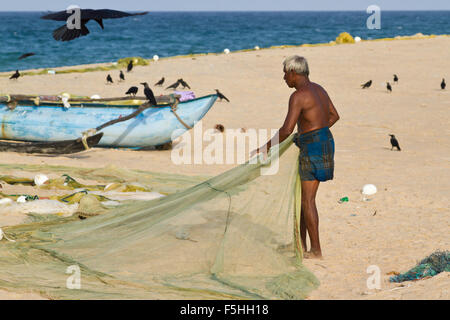 Traditional fisherman in canoe in Batticaloa, Sri Lanka Stock Photo