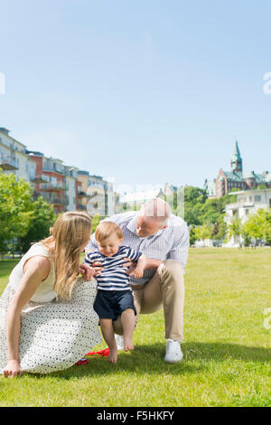 Sweden, Sodermanland, Nacka, Finnboda Hamn, Parents assisting son (18-23 months) with first steps Sweden, Sodermanland, Nacka, Finnboda Hamn, Parents assisting son (18-23 months) with first steps