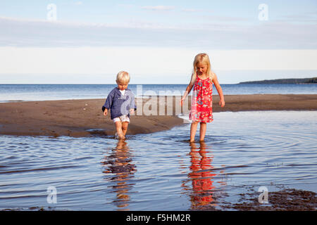 Sweden, Medelpad, Bergafjarden, Boy and girl (4-5) playing in water
