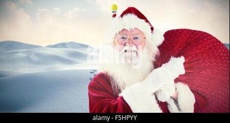 Composite image of jolly santa carries his sack Stock Photo