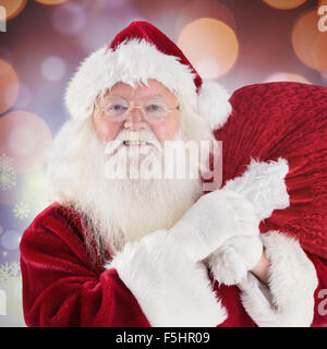 Composite image of jolly santa carries his sack Stock Photo