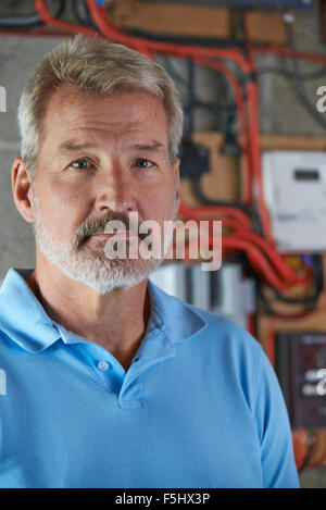 Portrait Of Electrician Standing Next To Fuseboard Stock Photo