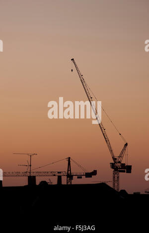 A sunset view of the Crest Nicholson tower cranes at the Paintworks, Bristol. Stock Photo