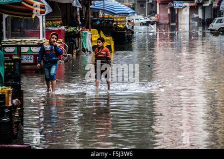 Alexandria, Alexandria, Egypt. 5th Nov, 2015. Egyptian boys walk in a flooded road following heavy rain storm, in Alexandria, Egypt, November 5, 2015. Eleven people were killed in floods in Beheira province north of Cairo, a security source said, and authorities evacuated 100 people from a village in the province as Egypt suffers from a second round of stormy weather in less than a month Credit:  Amr Sayed/APA Images/ZUMA Wire/Alamy Live News Stock Photo