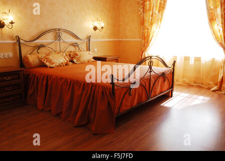 sunny romantic bedroom designed in orange pastel colours Stock Photo