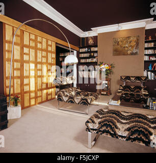 Black+gray swirl patterned velvet furniture in seventies townhouse living room with sixties floor Arc lamp Stock Photo