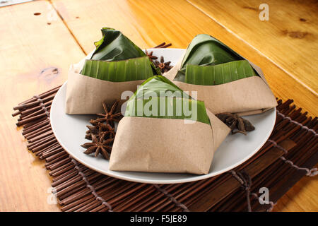 traditional fresh Malaysian nasi lemak packed with banana leaf in wood background Stock Photo