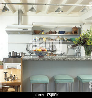 Pale turquoise leather+chrome stools at breakfast bar in a modern kitchen Stock Photo