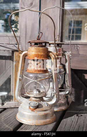 Rusted kerosene lamps stands on outdoor wooden table in Finland Stock Photo