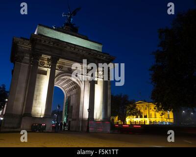 Cyclists riding through Wellington Arch at Hyde Park Corner in London at night Stock Photo
