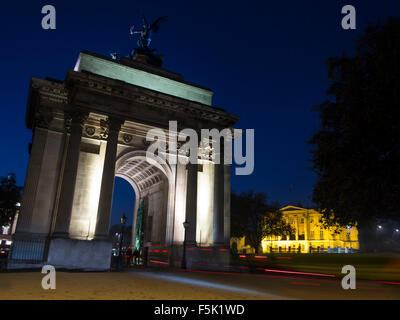 Cyclists riding through Wellington Arch at Hyde Park Corner in London at night Stock Photo