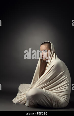 Girl posing as insane patient in straitjacket Stock Photo