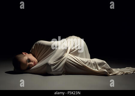 Studio image of mentally ill woman in straitjacket Stock Photo