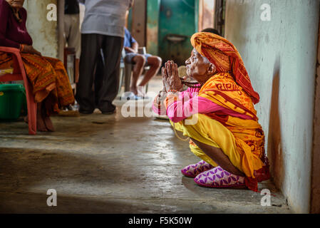 Elderly woman prays in a local retirement home Stock Photo