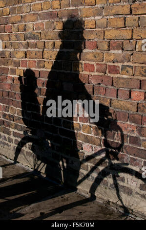 shadow of man and baby on bike Stock Photo