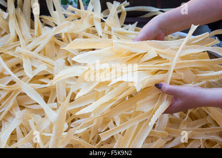 Homemade pasta in woman hands. Pasta production process Stock Photo