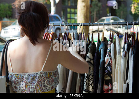 Young woman looks for a dress in an open air market in Portland Oregon. Stock Photo