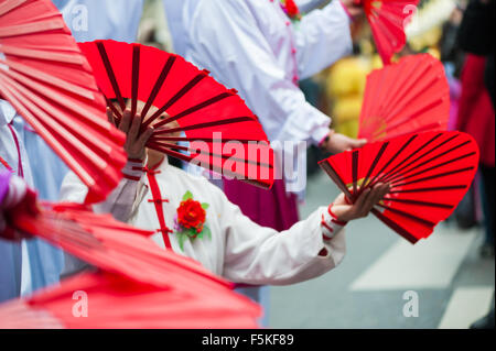 Paris, France - Feb 6, 2011: Performers dancing with red fans at the chinese lunar new year parade Stock Photo