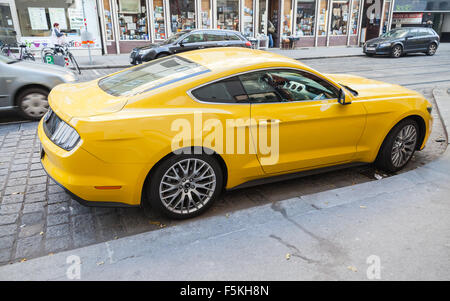 Vienna, Austria - November 4, 2015: Bright yellow Ford Mustang 2015 car stands on the city street, legendary sport car rear view Stock Photo