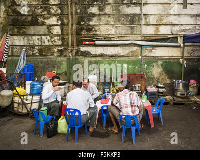 Yangon, Yangon Division, Myanmar. 6th Nov, 2015. Men eat and drink tea at an informal tea shop on a Yangon street. Some economists think Myanmar's informal economy is larger than the formal economy. Many people are self employed in cash only businesses like street food, occasional labor and day work, selling betel, or working out of portable street stalls, doing things like luggage repair. Despite reforms in Myanmar and the expansion of the economy, most people live on the informal economy. During a press conference this week, Burmese opposition leader Aung San Suu Kyi said, 'a great majo Stock Photo