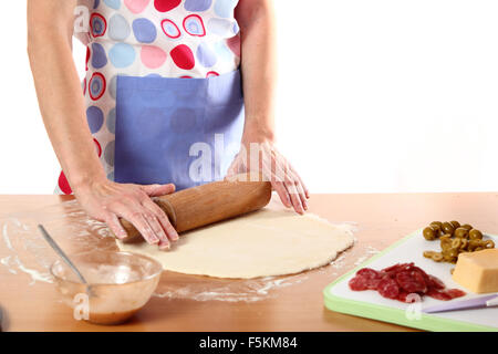 Preparing dough sheet for pizza. Rolling out. Making Pizza with Salami, Olives and Cheese. Series. Stock Photo