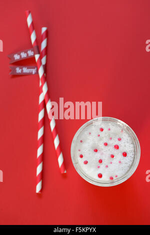 glass of milk and paper straws on red background Stock Photo