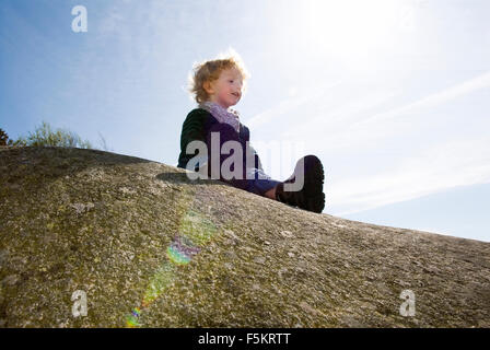 Sweden, Bohuslan, Boy (4-5) sitting on rock Stock Photo